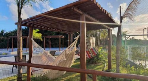 ein paar Hängematten vor einem Haus in der Unterkunft Apartamento moderno com Piscina e Coworking in Parnamirim