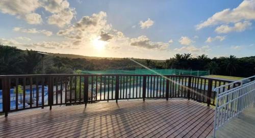 einen Balkon mit Blick auf das Meer und die Sonne in der Unterkunft Apartamento moderno com Piscina e Coworking in Parnamirim