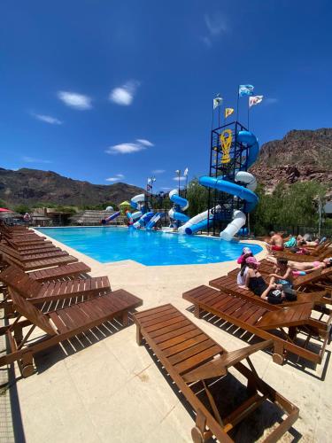 a pool with a water park with people sitting on benches at Posada Rojo Malbec in San Rafael