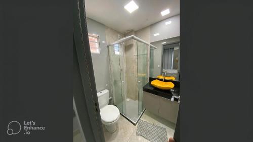 a bathroom with a toilet and a glass shower at Apto elegante no Catolé 33 in Campina Grande