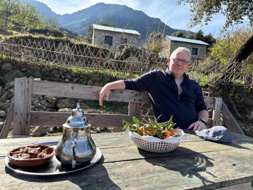 un homme assis à une table avec un bol de nourriture dans l'établissement Le Sommet Naturel, à Chefchaouen