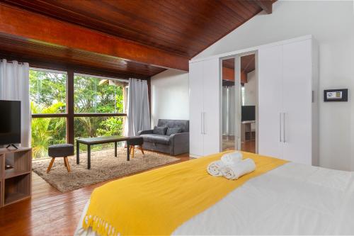 a bedroom with a bed and a living room at Departamento Dos reis in Búzios