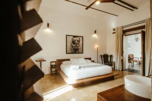 a bedroom with a bed and a bathroom with a tub at Hotel Sin Nombre in Oaxaca City