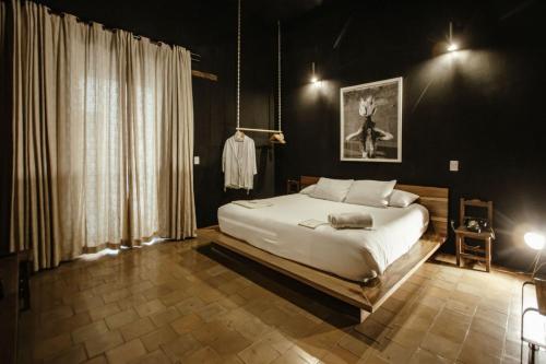 een slaapkamer met een groot wit bed in een kamer bij Hotel Sin Nombre in Oaxaca City