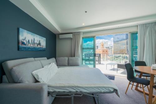 a living room with a bed and a large window at Chic Princes Wharf Studio - City View - Parking in Auckland