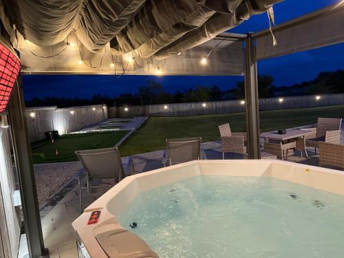 een jacuzzi op een patio met een tafel en stoelen bij Knockalla Lodge in Ballygowan