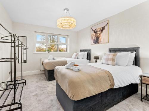a bedroom with two beds and a chandelier at Spacious 3BR 3-Bath Modern Home Warrington in Warrington