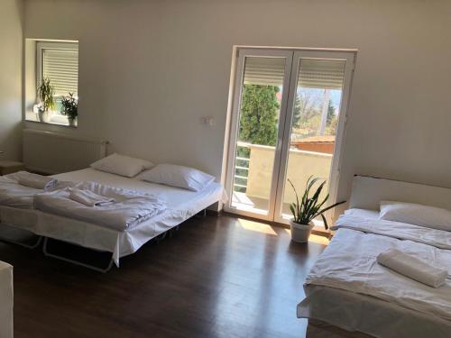 a bedroom with two beds and a large window at NOVA residence in Sarajevo