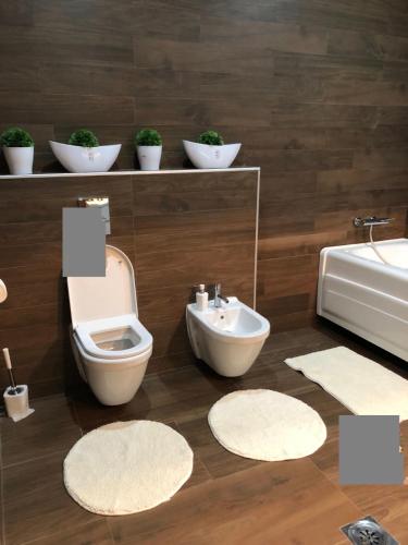 a bathroom with a toilet and a sink and mirrors at NOVA residence in Sarajevo