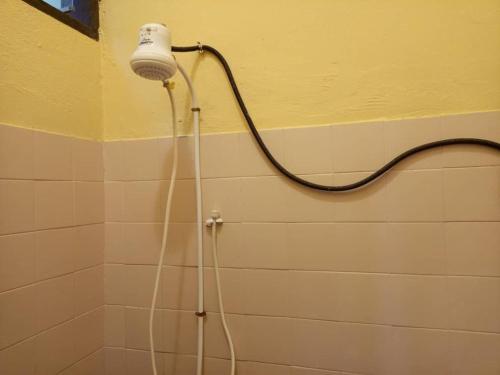 a shower with a blow dryer in a bathroom at Titi garage meublé in Yaoundé