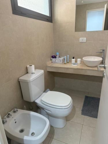 a bathroom with a white toilet and a sink at Escobar Centro II in Belén de Escobar