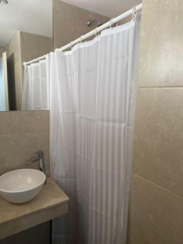 a bathroom with a white shower curtain and a sink at Escobar Centro II in Belén de Escobar