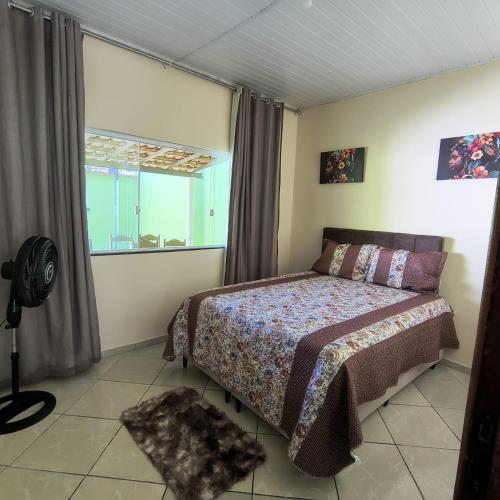 een slaapkamer met een bed en een raam bij Casa Temporada Prado-BA in Prado