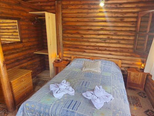 a bedroom with a bed in a log cabin at Cabañas Lumel in Carpintería