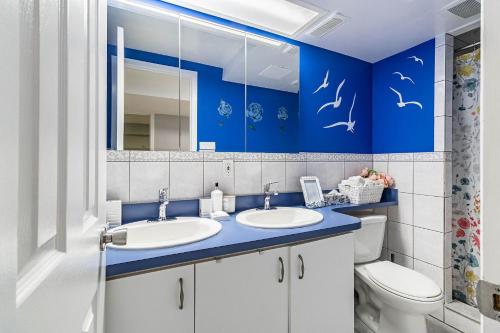 ein Badezimmer mit zwei Waschbecken und einer blauen Wand in der Unterkunft Entire Basement Apartment in Toronto
