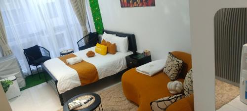 - une chambre avec deux lits, une chaise et un canapé dans l'établissement Elite escape Homes, à Nairobi