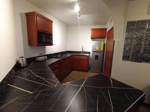 a kitchen with black marble counter tops and wooden cabinets at Luxury Suites New York Historic Center in Chihuahua