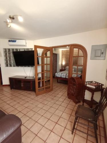 a living room with a couch and a tv and a bed at Luxury Suites New York Historic Center in Chihuahua