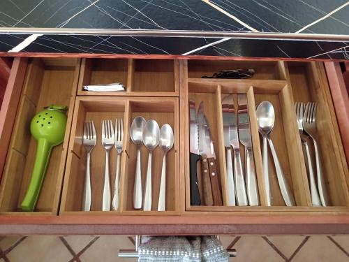 a wooden drawer with utensils in a cabinet at Luxury Suites New York Historic Center in Chihuahua