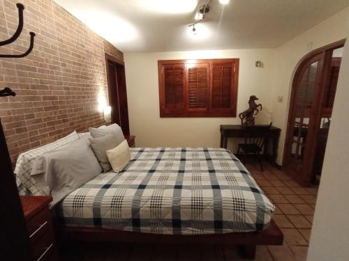 a bedroom with a bed and a brick wall at Luxury Suites New York Historic Center in Chihuahua