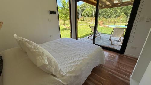 a bedroom with a bed with a view of a patio at Laguna y Tierra in Chascomús