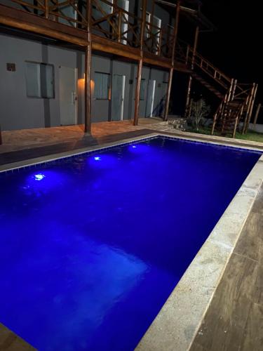een blauw zwembad 's nachts bij Suítes Taipu de Fora in Marau