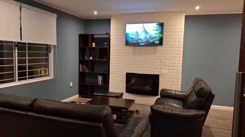 un soggiorno con un divano e una televisione su una parete di La Esquina a Punta del Este