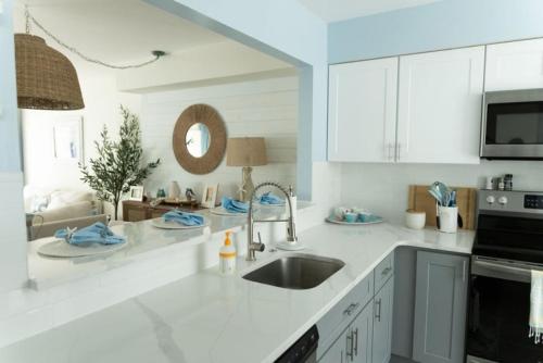 a white kitchen with a sink and a microwave at 114 Austin Ave, Unit 11 in Wildwood