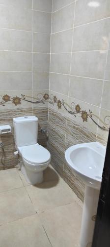 a bathroom with a toilet and a sink at كومباوند وصال الشروق in Madīnat ash Shurūq