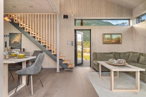 a living room with a couch and a table at Hoda Cabin - Luxury lodge with jacuzzi and sauna in Lyngværet