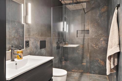 a bathroom with a sink and a shower at Hoda Cabin - Luxury lodge with jacuzzi and sauna in Lyngværet