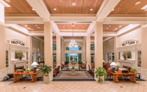 a lobby of a hotel with tables and chairs at Cypress Bend Resort, a Wyndham Hotel in Many