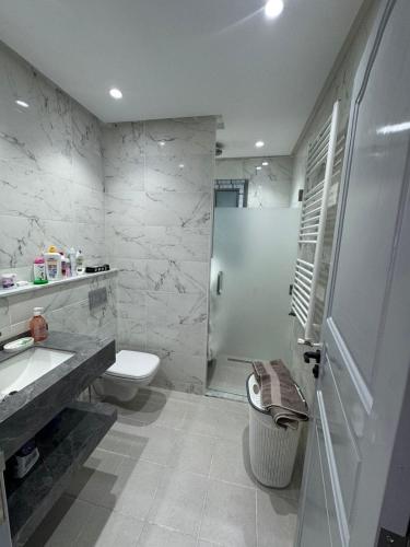 a bathroom with a toilet and a sink and a shower at Villa neuve avec une grande terrasse in Dar Tahar Zaouch