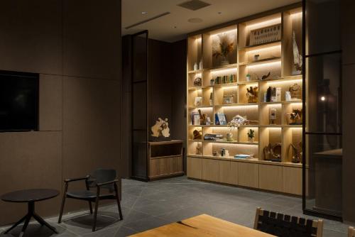 a room with a table and a shelf with vases at Miyako City Osaka Hommachi in Osaka