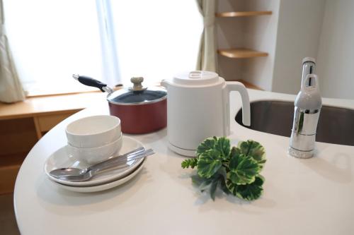 een wit aanrechtblad met keukengerei en planten erop bij Hotel LEAP in Osaka