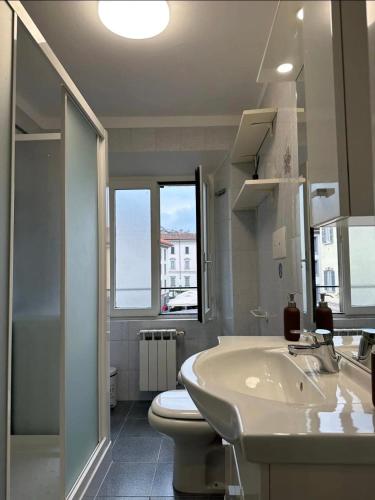 a white bathroom with a sink and a toilet at Como Lake, lakefront 30m in Como