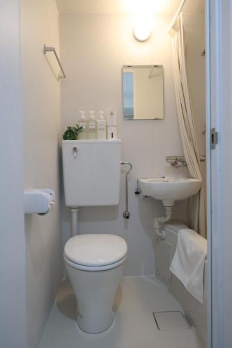 a white bathroom with a toilet and a sink at Hotel LEAP in Osaka