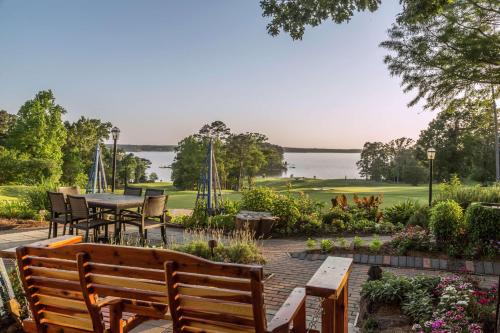 a patio with a table and chairs and a view of the water at Cypress Bend Resort, a Wyndham Hotel in Many