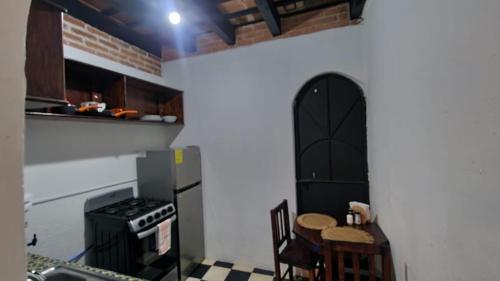 a kitchen with a black refrigerator and a table and chairs at Refugio de las Estrellas in Antigua Guatemala