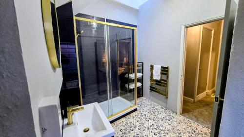 een badkamer met een wastafel en een glazen douche bij The Maisonette central Buxton in Buxton