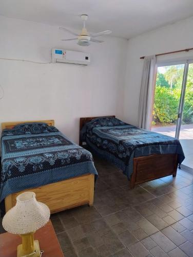 a bedroom with a bed and a lamp and a window at Casa Punta Iglesia in Paso de la Patria