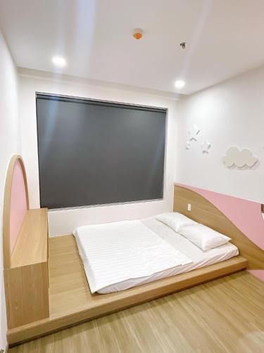 a bed in a room with a large window at Happy One Central in Trạm Chánh An
