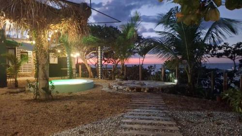 een achtertuin met een zwembad en palmbomen bij Habitación, balcón frente al mar y alberca in Lerma