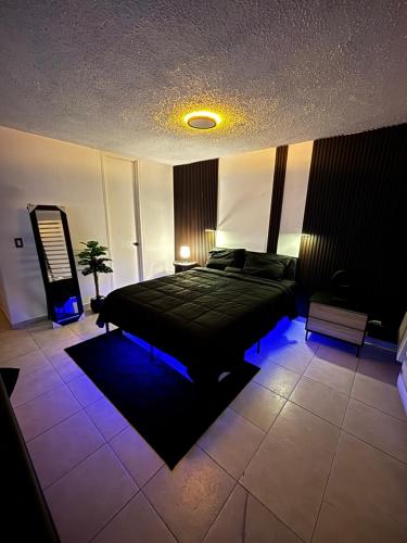 a bedroom with a black bed with blue lights at Son de Metro Apartment - Condado Beach & Pool, Walk to Ocean in San Juan