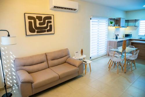 a living room with a couch and a kitchen at Casa Bárbara Totalmente Nueva in Hermosillo
