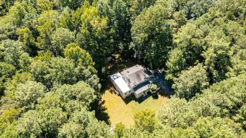 een luchtfoto van een huis midden in een bos bij Quiet Retreat - Piano Firepit Peloton in Pittsboro