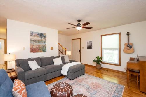 een woonkamer met een bank en een plafondventilator bij Quiet Retreat - Piano Firepit Peloton in Pittsboro