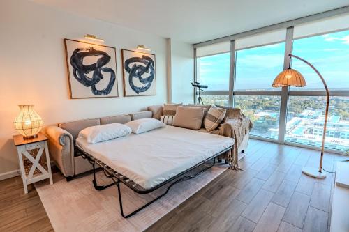 a living room with a couch and a large window at Skyline Serenity City Views, Pool, Hot Tub & Gym in Fort Myers