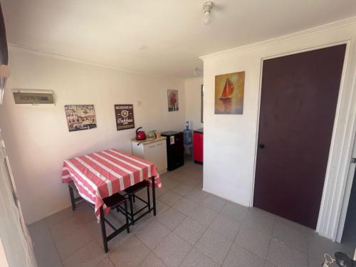 a room with a table and a kitchen with a refrigerator at Gadir hostel in Coquimbo