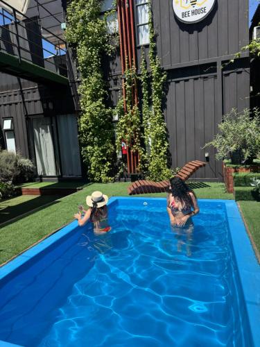 twee mensen in het water in een zwembad bij Casa Withe opción jacuzzi in Villa Alemana